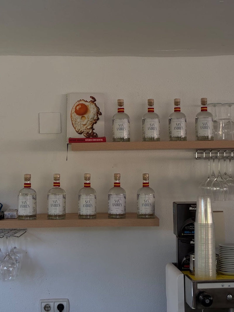 Botellas de San Andrés en unas baldas de madera de un bar