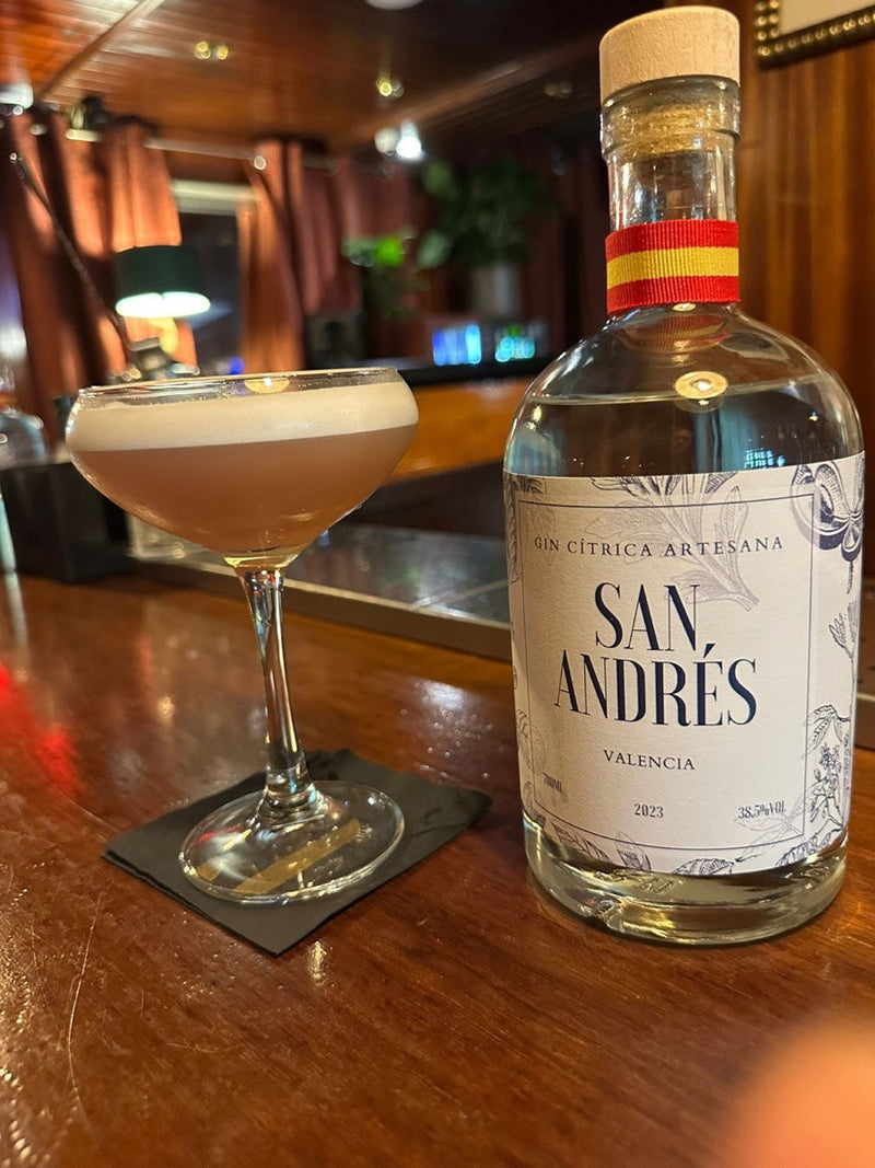 Sour con espuma junto a una botella de San Andrés