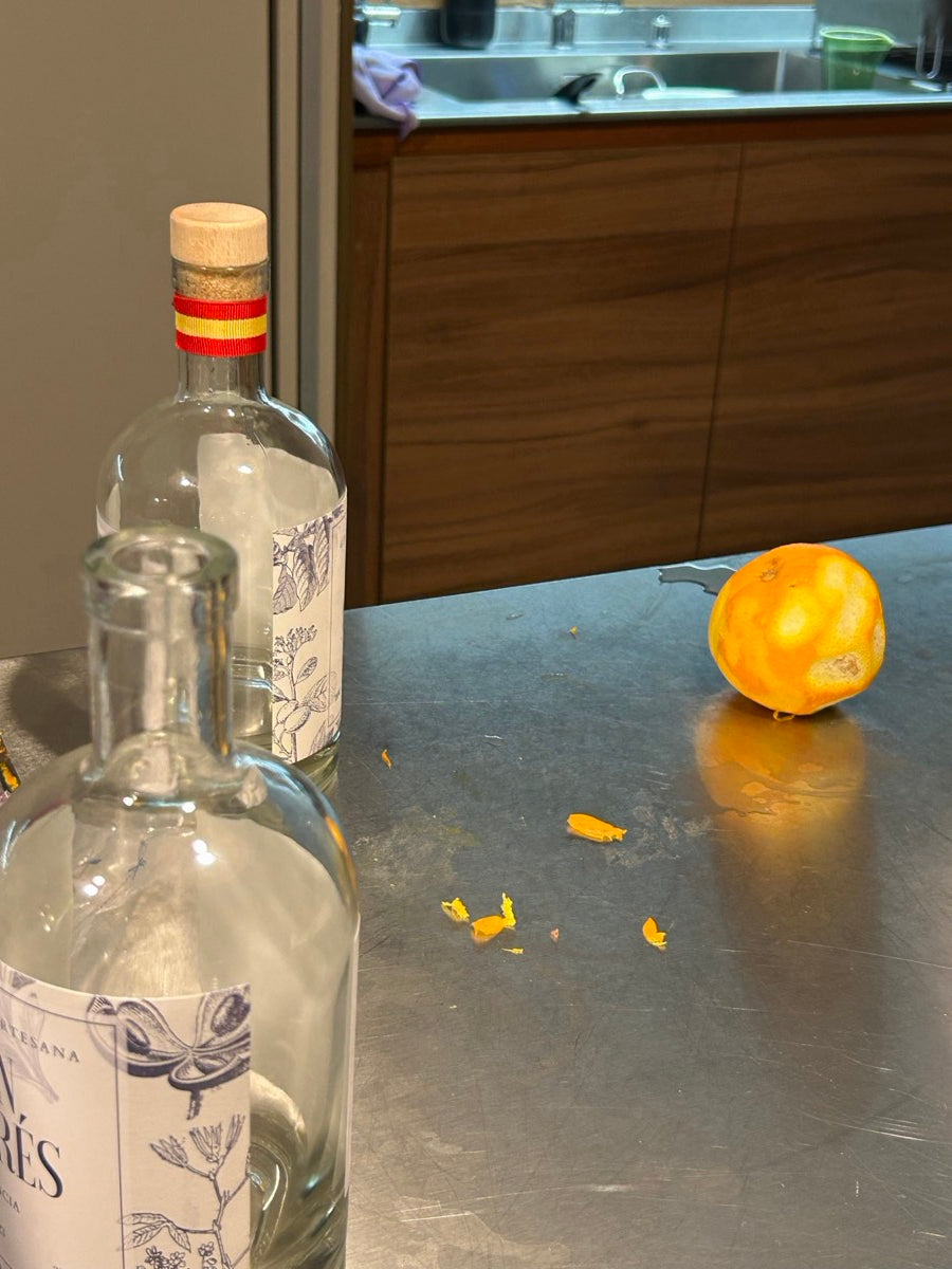 Una mandarina y sus pieles junto a la botella