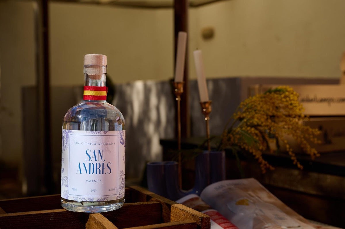 Botella de San Andrés en una mesa con velas